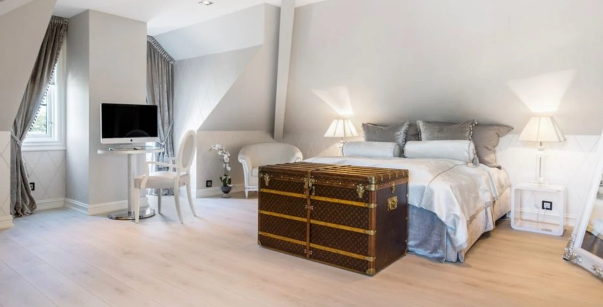 Elegant attic bedroom with luxury trunk and sophisticated design