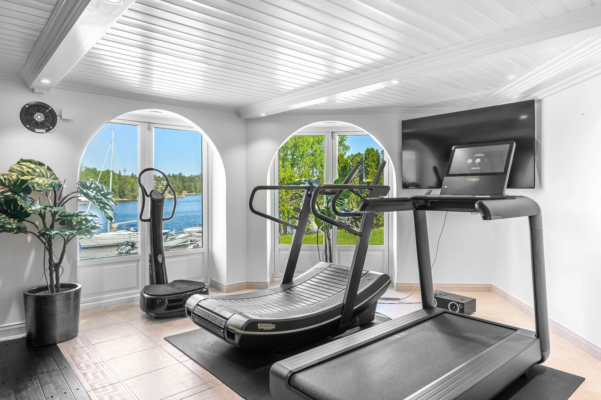 Cardio equipment with waterfront views through circular windows