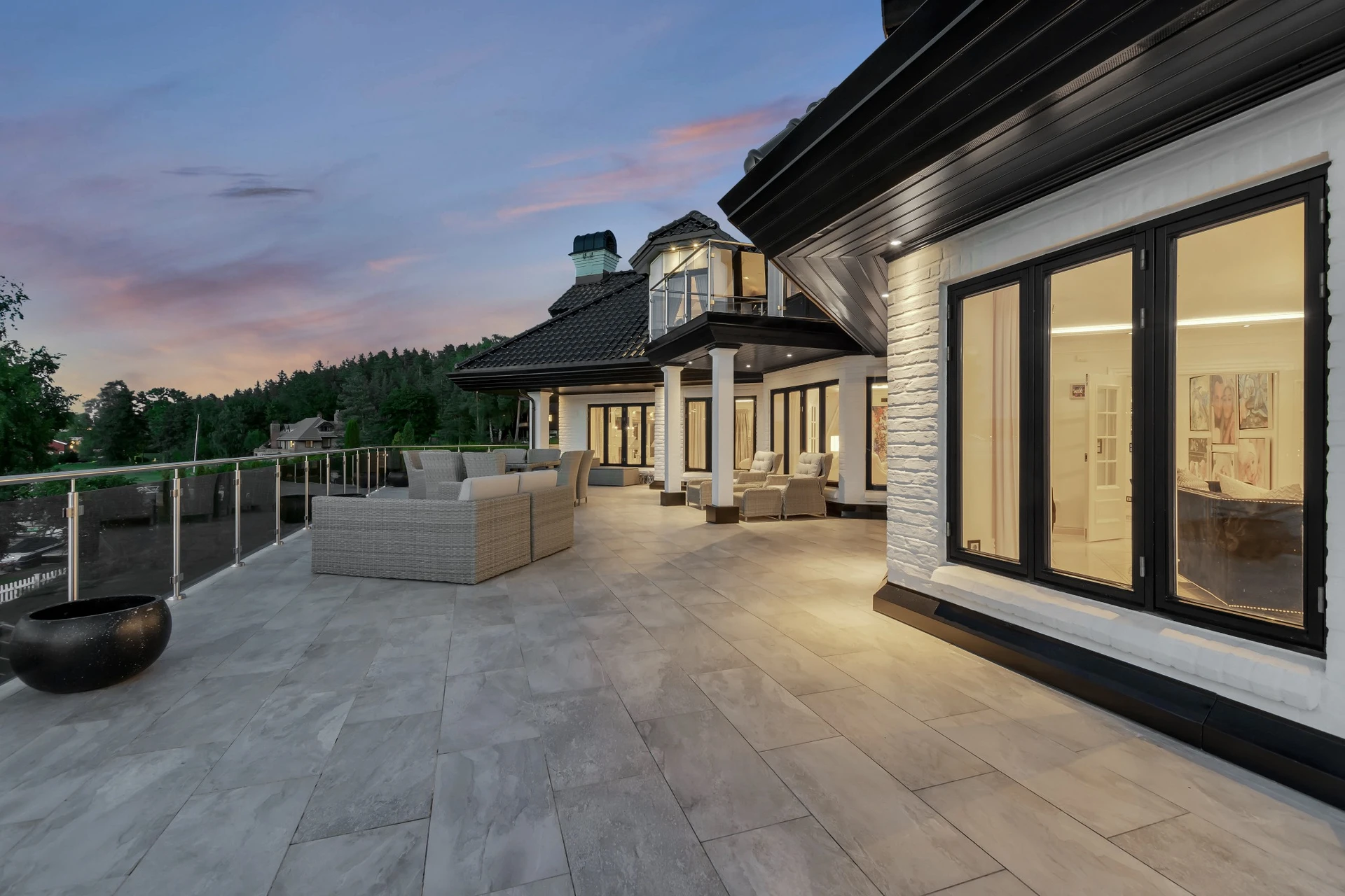 Expansive luxury terrace with outdoor furniture at sunset